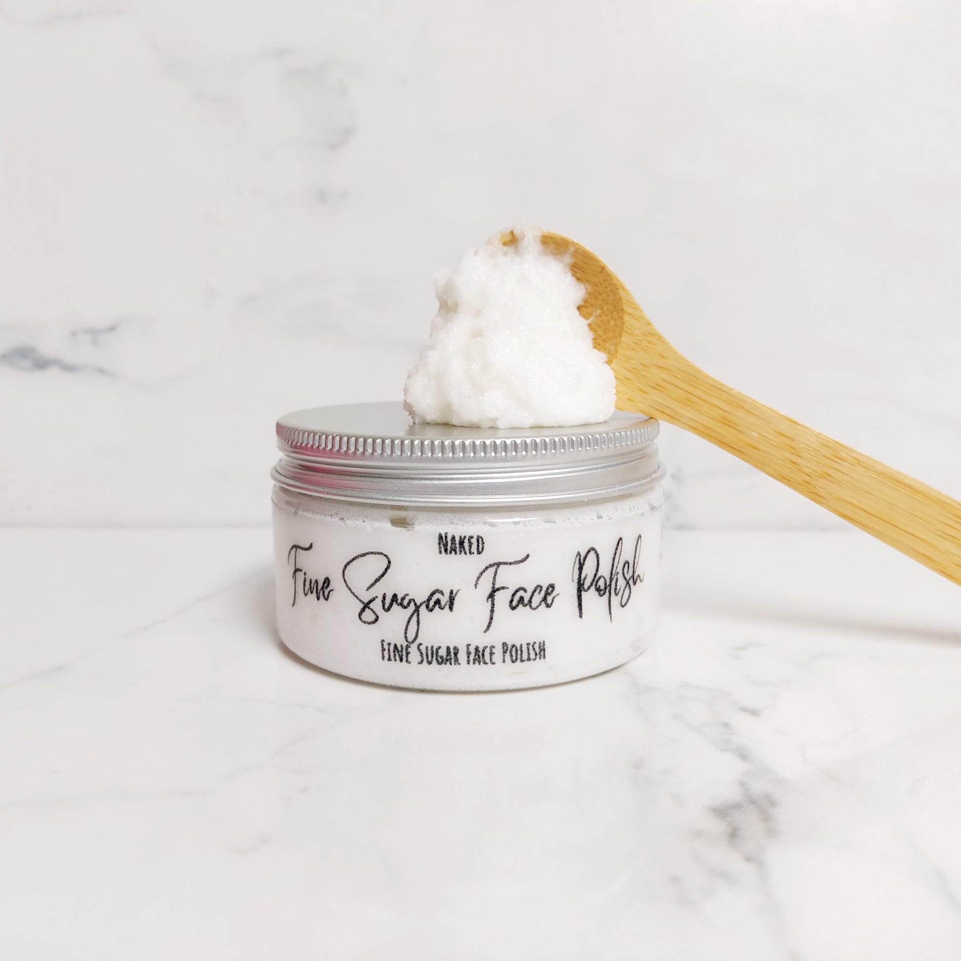 Fine sugar face polish, caster sugar face scrub, face scrub, clear short tube with an aluminium lid. Cosmetic Oils and butters with caster sugar face scrub. 